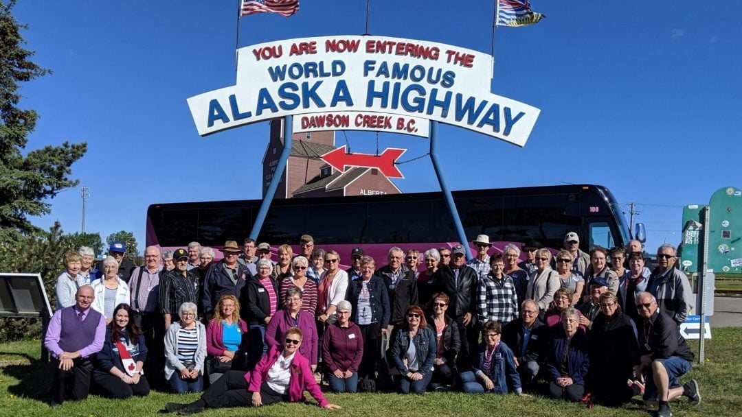 tour group at mile zero of Alaska Highway